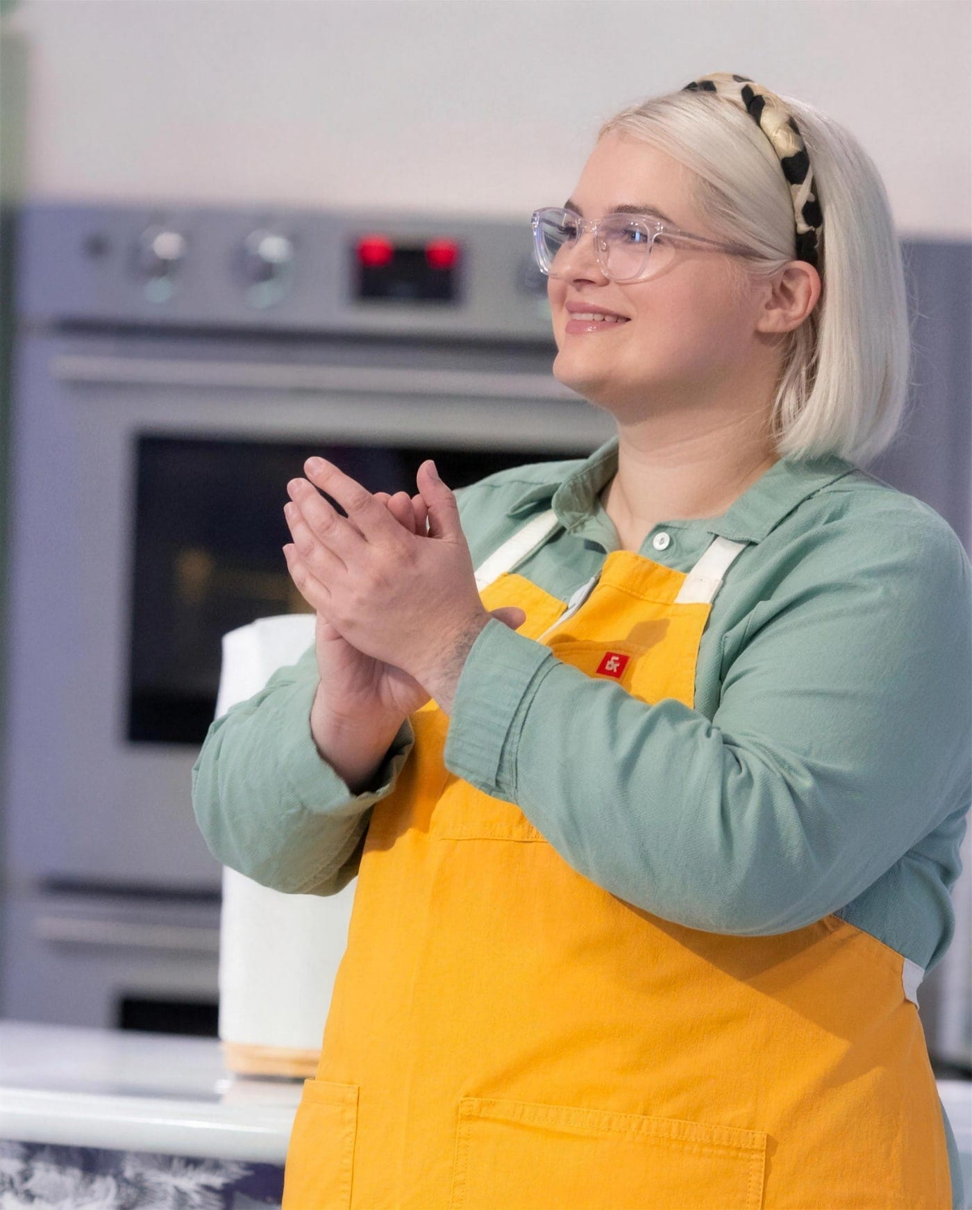 Chloe Maguire decorating a cake in her kitchen